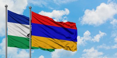 Lesotho ve Ermenistan bayrağı birlikte beyaz bulutlu mavi gökyüzüne karşı rüzgarda sallayarak. Diplomasi kavramı, uluslararası ilişkiler.