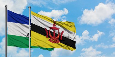 Lesotho ve Brunei bayrağı birlikte beyaz bulutlu mavi gökyüzüne karşı rüzgarda sallayarak. Diplomasi kavramı, uluslararası ilişkiler.
