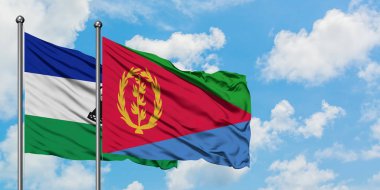 Lesotho ve Eritre bayrağı birlikte beyaz bulutlu mavi gökyüzüne karşı rüzgarda sallayarak. Diplomasi kavramı, uluslararası ilişkiler.