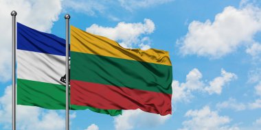 Lesotho ve Litvanya bayrağı birlikte beyaz bulutlu mavi gökyüzüne karşı rüzgarda sallayarak. Diplomasi kavramı, uluslararası ilişkiler.