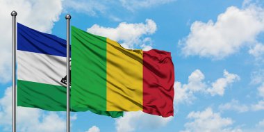 Lesotho ve Mali bayrağı birlikte beyaz bulutlu mavi gökyüzüne karşı rüzgarda sallayarak. Diplomasi kavramı, uluslararası ilişkiler.