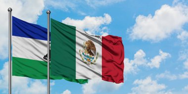 Lesotho ve Meksika bayrağı birlikte beyaz bulutlu mavi gökyüzüne karşı rüzgarda sallayarak. Diplomasi kavramı, uluslararası ilişkiler.