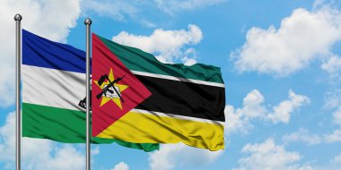 Lesotho ve Mozambik bayrağı birlikte beyaz bulutlu mavi gökyüzüne karşı rüzgarda sallayarak. Diplomasi kavramı, uluslararası ilişkiler.