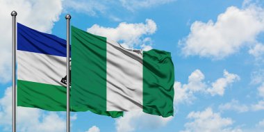 Lesotho and Nigeria flag waving in the wind against white cloudy blue sky together. Diplomacy concept, international relations.