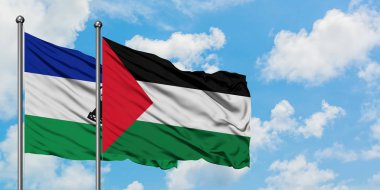 Lesotho and Palestine flag waving in the wind against white cloudy blue sky together. Diplomacy concept, international relations.