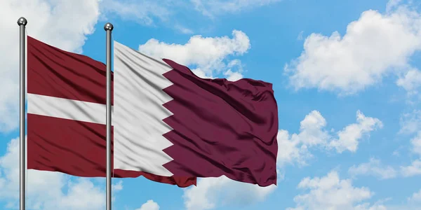 Латвія та прапор Катару розмахували вітром проти білого хмарного синього неба. Концепція дипломатії, міжнародні відносини. — стокове фото