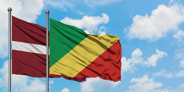 Łotwa i Republika Konga flaga machając w wiatr przed białym zachmurzone błękitne niebo razem. Koncepcja dyplomacji, stosunki międzynarodowe. — Zdjęcie stockowe