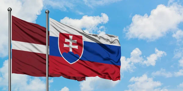 Латвія і Словаччина прапор розмахував вітром проти білого хмарного синього неба разом. Концепція дипломатії, міжнародні відносини. — стокове фото