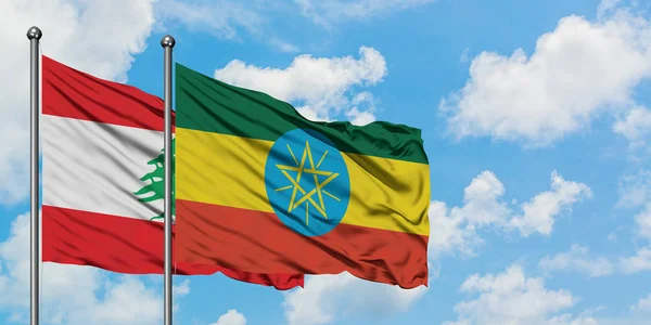 Bandera de Líbano y Etiopía ondeando en el viento contra el cielo azul nublado blanco juntos. Concepto diplomático, relaciones internacionales . — Foto de Stock