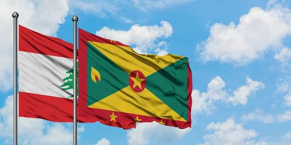 Die libanesische und die Grenada-Flagge wehen gemeinsam im Wind vor dem wolkenverhangenen blauen Himmel. Diplomatie-Konzept, internationale Beziehungen. — Stockfoto