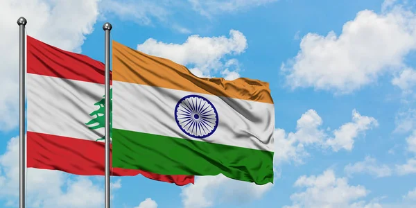 Bandera del Líbano y la India ondeando en el viento contra el cielo azul nublado blanco juntos. Concepto diplomático, relaciones internacionales . — Foto de Stock