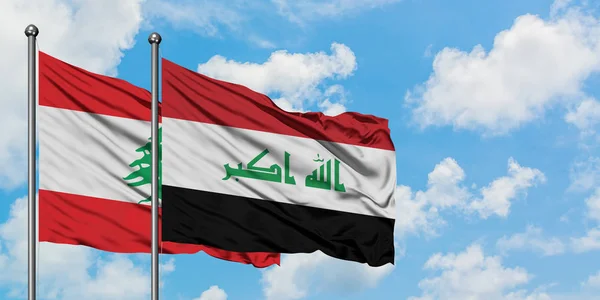 A bandeira do Líbano e do Iraque agitando no vento contra o céu azul nublado branco juntos. Conceito de diplomacia, relações internacionais . — Fotografia de Stock