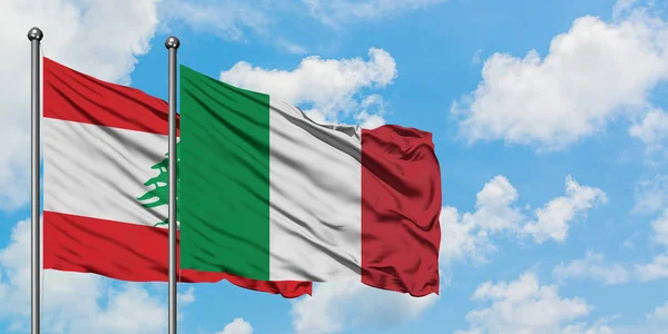 Bandera de Líbano e Italia ondeando en el viento contra el cielo azul nublado blanco juntos. Concepto diplomático, relaciones internacionales . — Foto de Stock