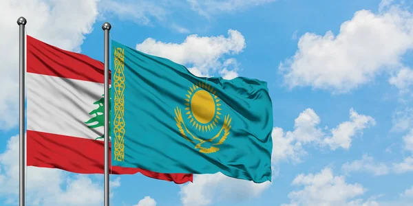 Bandera del Líbano y Kazajstán ondeando en el viento contra el cielo azul nublado blanco juntos. Concepto diplomático, relaciones internacionales . — Foto de Stock