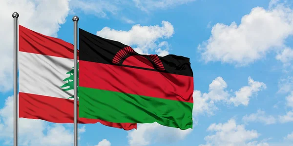 Bandera de Líbano y Malawi ondeando en el viento contra el cielo azul nublado blanco juntos. Concepto diplomático, relaciones internacionales . — Foto de Stock