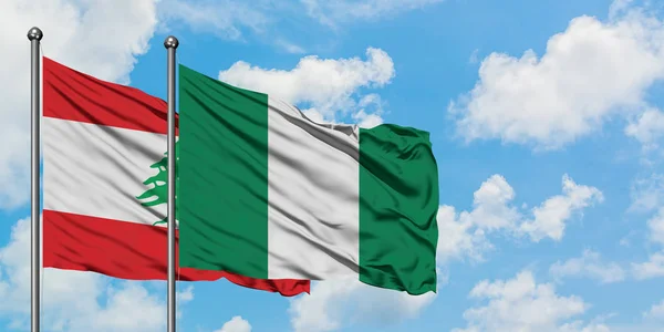 Bandera de Líbano y Nigeria ondeando en el viento contra el cielo azul nublado blanco juntos. Concepto diplomático, relaciones internacionales . — Foto de Stock