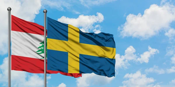 Libanon a švédská vlajka mávali ve větru proti bíle zatažené modré obloze. Diplomacie, mezinárodní vztahy. — Stock fotografie