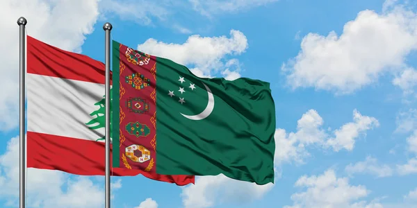 Bandera de Líbano y Turkmenistán ondeando en el viento contra el cielo azul nublado blanco juntos. Concepto diplomático, relaciones internacionales . — Foto de Stock
