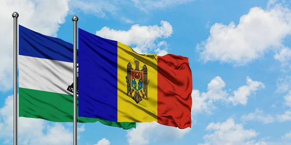 Лесото і Молдова розмахував вітром проти білого хмарного синього неба разом. Концепція дипломатії, міжнародні відносини. — стокове фото