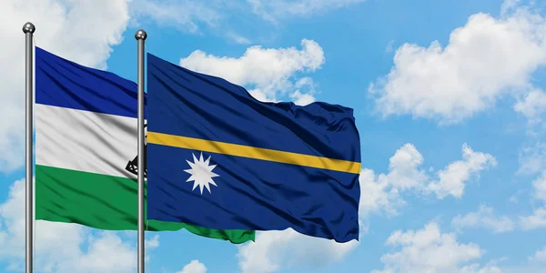 Lesotho und nauru Flagge wehen im Wind vor weißem wolkenblauem Himmel zusammen. Diplomatie-Konzept, internationale Beziehungen. — Stockfoto