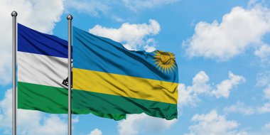 Lesotho and Rwanda flag waving in the wind against white cloudy blue sky together. Diplomacy concept, international relations.