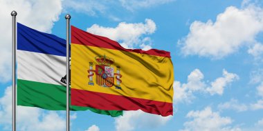 Lesotho ve İspanya bayrağı birlikte beyaz bulutlu mavi gökyüzüne karşı rüzgarda sallayarak. Diplomasi kavramı, uluslararası ilişkiler.