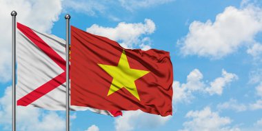 Jersey ve Vietnam bayrağı birlikte beyaz bulutlu mavi gökyüzüne karşı rüzgarda sallayarak. Diplomasi kavramı, uluslararası ilişkiler.