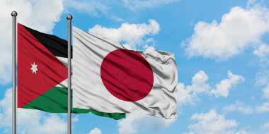 Ürdün ve Japonya bayrağı birlikte beyaz bulutlu mavi gökyüzüne karşı rüzgarda sallayarak. Diplomasi kavramı, uluslararası ilişkiler.