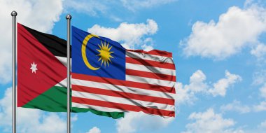 Ürdün ve Malezya bayrağı birlikte beyaz bulutlu mavi gökyüzüne karşı rüzgarda sallayarak. Diplomasi kavramı, uluslararası ilişkiler.