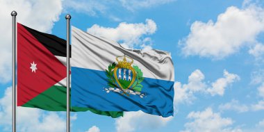 Ürdün ve San Marino bayrağı birlikte beyaz bulutlu mavi gökyüzüne karşı rüzgarda sallayarak. Diplomasi kavramı, uluslararası ilişkiler.