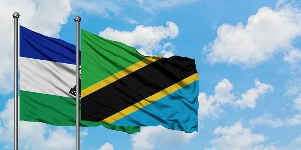 Lesotho and Tanzania flag waving in the wind against white cloudy blue sky together. Diplomacy concept, international relations. — Stock Photo, Image