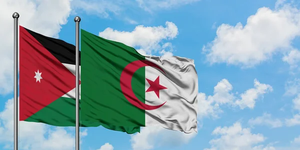 Jordanië en Algerije vlag zwaaien in de wind tegen witte bewolkte blauwe hemel samen. Diplomatie concept, internationale betrekkingen. — Stockfoto