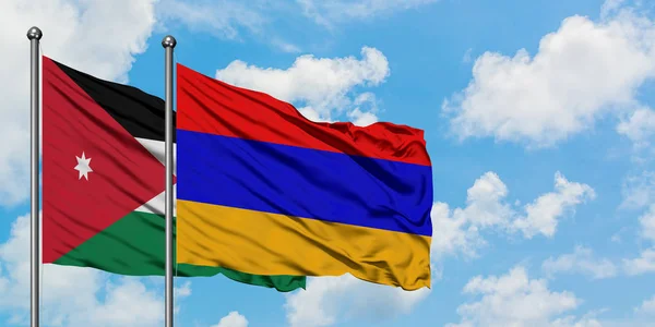 Bandera de Jordania y Armenia ondeando en el viento contra el cielo azul nublado blanco juntos. Concepto diplomático, relaciones internacionales . — Foto de Stock