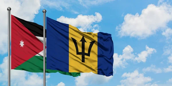 Bandera de Jordania y Barbados ondeando en el viento contra el cielo azul nublado blanco juntos. Concepto diplomático, relaciones internacionales . — Foto de Stock