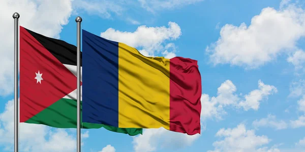 Bandera de Jordania y Chad ondeando en el viento contra el cielo azul nublado blanco juntos. Concepto diplomático, relaciones internacionales . — Foto de Stock