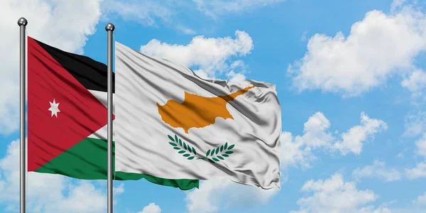 Bandera de Jordania y Chipre ondeando en el viento contra el cielo azul nublado blanco juntos. Concepto diplomático, relaciones internacionales . — Foto de Stock