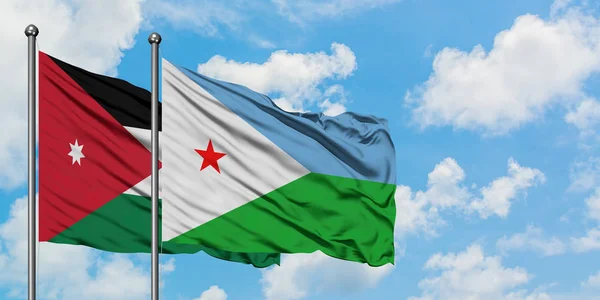 Jordania y la bandera de Djibouti ondeando en el viento contra el cielo azul nublado blanco juntos. Concepto diplomático, relaciones internacionales . — Foto de Stock