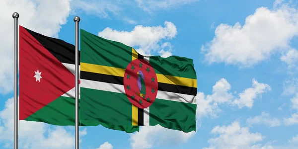Bandera de Jordania y Dominica ondeando en el viento contra el cielo azul nublado blanco juntos. Concepto diplomático, relaciones internacionales . — Foto de Stock