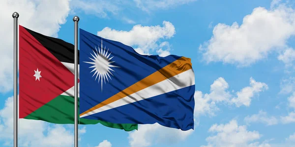 Bandera de Jordania y las Islas Marshall ondeando en el viento contra el cielo azul nublado blanco juntos. Concepto diplomático, relaciones internacionales . — Foto de Stock