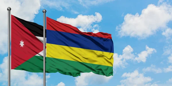 Bandera de Jordania y Mauricio ondeando en el viento contra el cielo azul nublado blanco juntos. Concepto diplomático, relaciones internacionales . — Foto de Stock