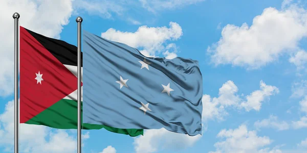 Bandera de Jordania y Micronesia ondeando en el viento contra el cielo azul nublado blanco juntos. Concepto diplomático, relaciones internacionales . — Foto de Stock