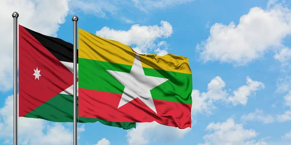 Bandera de Jordania y Myanmar ondeando en el viento contra el cielo azul nublado blanco juntos. Concepto diplomático, relaciones internacionales . — Foto de Stock