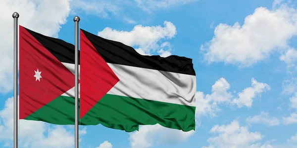 Bandera de Jordania y Palestina ondeando en el viento contra el cielo azul nublado blanco juntos. Concepto diplomático, relaciones internacionales . — Foto de Stock