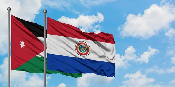 Bandera de Jordania y Paraguay ondeando en el viento contra el cielo azul nublado blanco juntos. Concepto diplomático, relaciones internacionales . — Foto de Stock