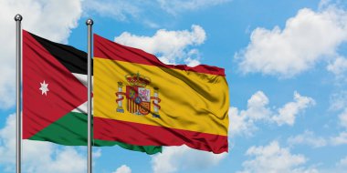 Ürdün ve İspanya bayrağı birlikte beyaz bulutlu mavi gökyüzüne karşı rüzgarda sallayarak. Diplomasi kavramı, uluslararası ilişkiler.