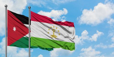 Ürdün ve Tacikistan bayrağı birlikte beyaz bulutlu mavi gökyüzüne karşı rüzgarda sallayarak. Diplomasi kavramı, uluslararası ilişkiler.