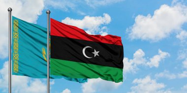 Kazakistan ve Libya bayrağı birlikte beyaz bulutlu mavi gökyüzüne karşı rüzgarsal sallayarak. Diplomasi kavramı, uluslararası ilişkiler.