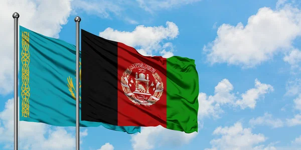 Bandera de Kazajstán y Afganistán ondeando en el viento contra el cielo azul nublado blanco juntos. Concepto diplomático, relaciones internacionales . — Foto de Stock