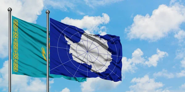 Bandera de Kazajstán y la Antártida ondeando en el viento contra el cielo azul nublado blanco juntos. Concepto diplomático, relaciones internacionales . — Foto de Stock