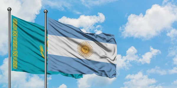 Bandera de Kazajstán y Argentina ondeando en el viento contra el cielo azul nublado blanco juntos. Concepto diplomático, relaciones internacionales . —  Fotos de Stock
